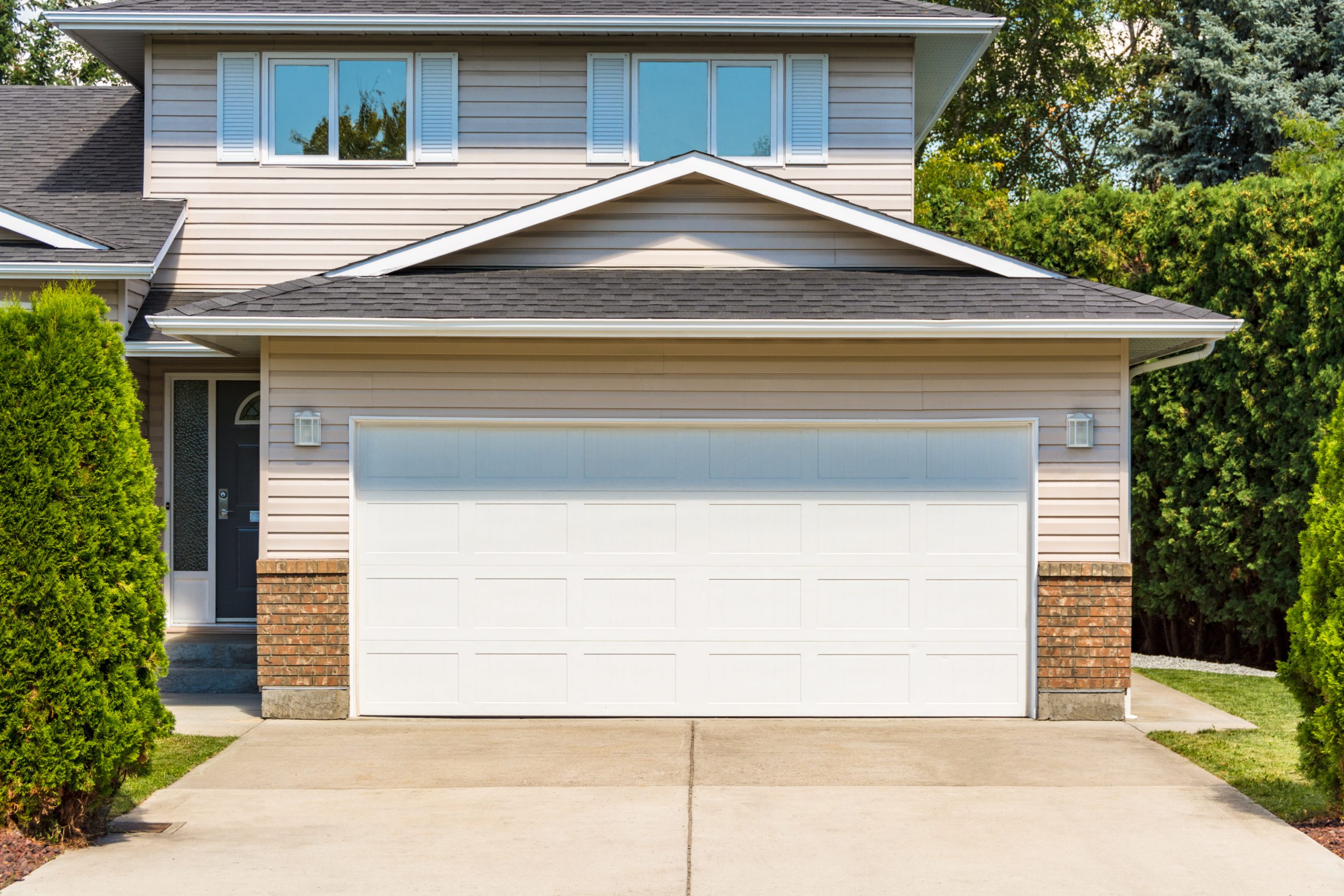 Garage Remodels White wide garage door of residential house with concrete drivew Garage Remodels